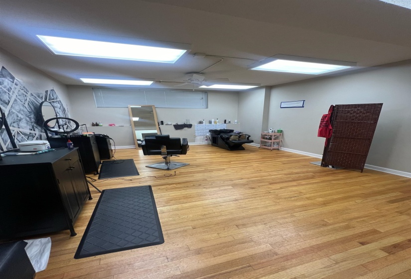 Workout area with baseboards, light wood-type flooring, and ceiling fan