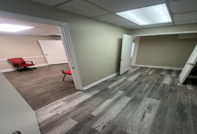 Interior space featuring baseboards, a paneled ceiling, and wood finished floors