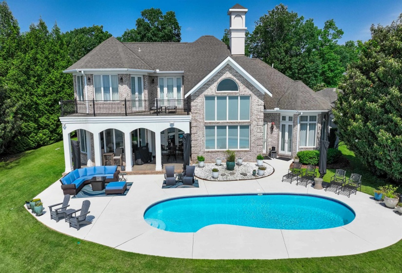Rear view of house featuring a balcony, a patio, a lawn, french doors, and an outdoor hangout area