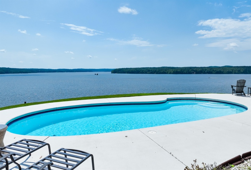 Outdoor pool featuring a water view and a patio