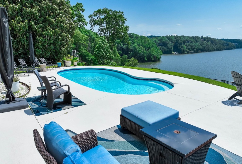 Outdoor pool featuring a water view and a patio
