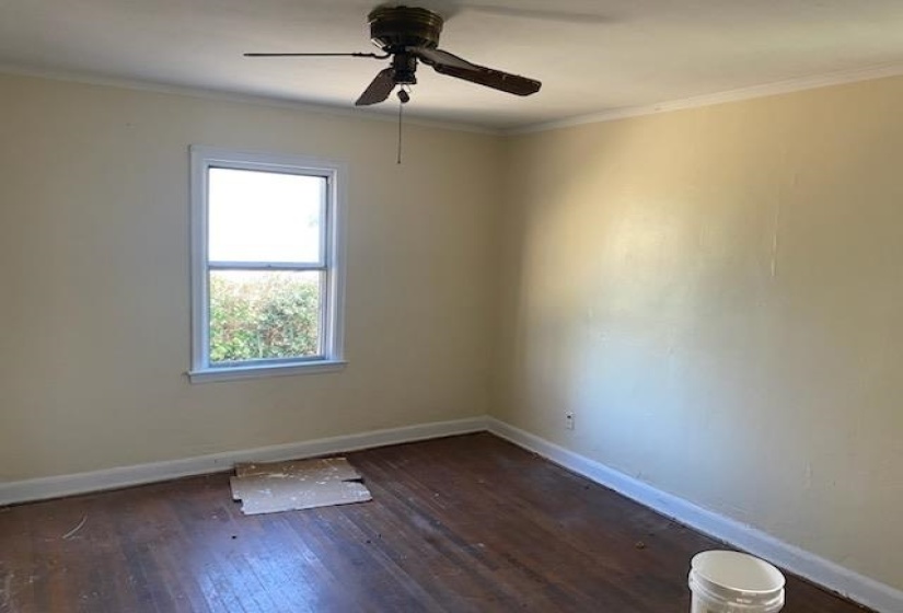 Unfurnished room with crown molding, baseboards, and wood finished floors