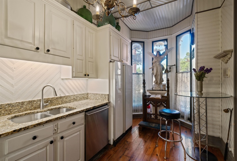 Kitchen with white cabinetry, light stone countertops, stainless steel dishwasher, dark hardwood / wood-style floors, and sink