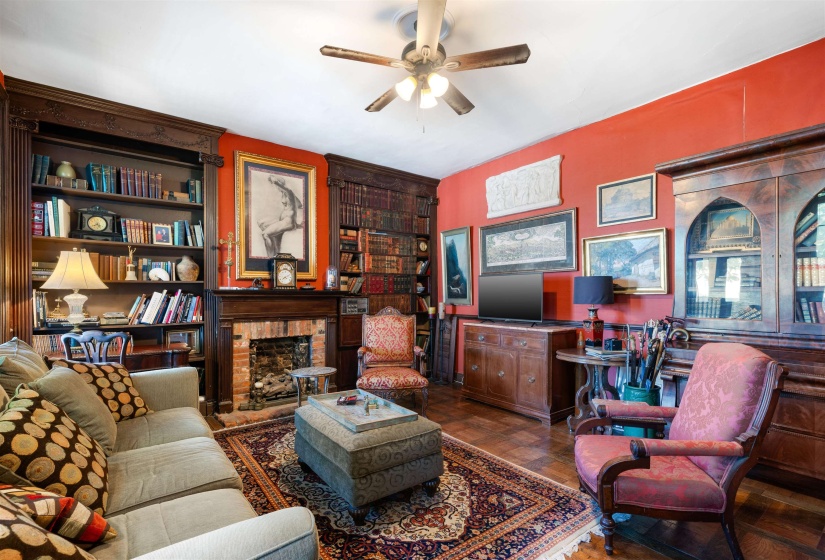 Living room with a brick fireplace and ceiling fan