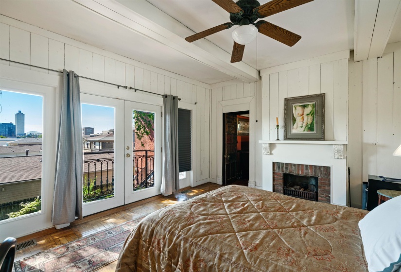 Bedroom with ceiling fan, french doors, beamed ceiling, a fireplace, and access to exterior