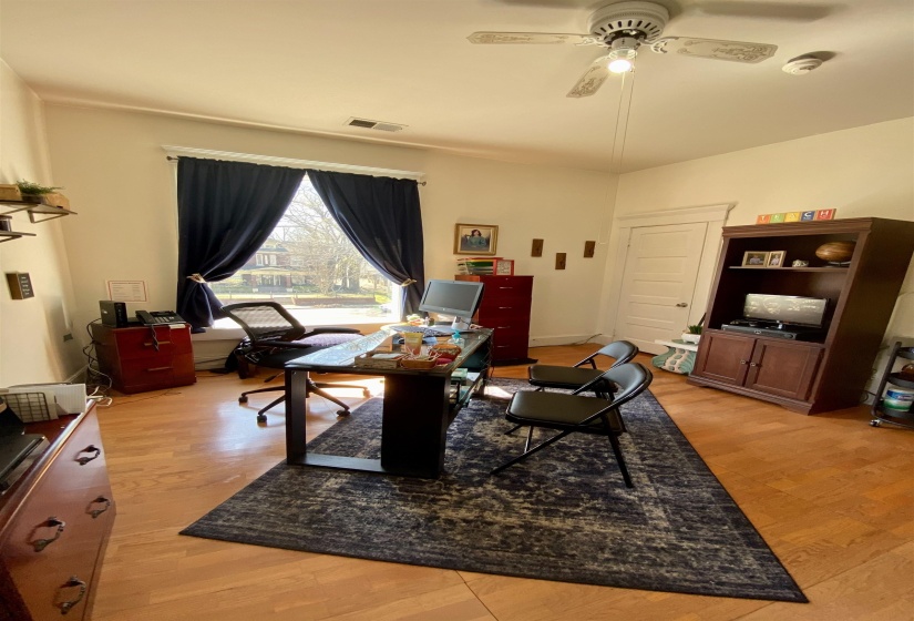 Office featuring a ceiling fan, visible vents, and light wood-type flooring