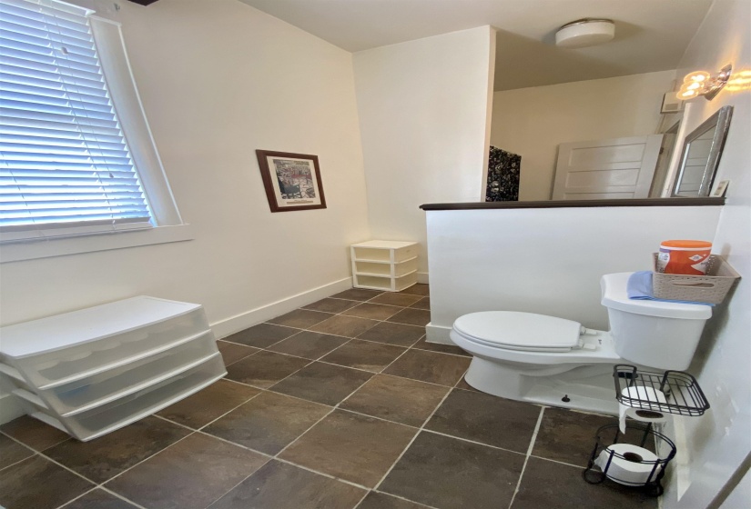 Bathroom with toilet, tile patterned floors, baseboards, and walk in shower