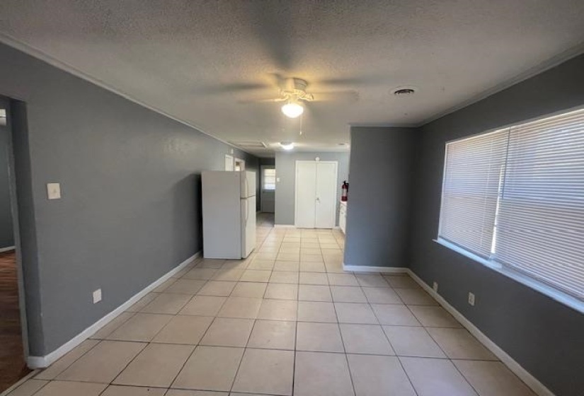 Unfurnished room with baseboards, a textured ceiling, light tile patterned flooring, visible vents, and ceiling fan