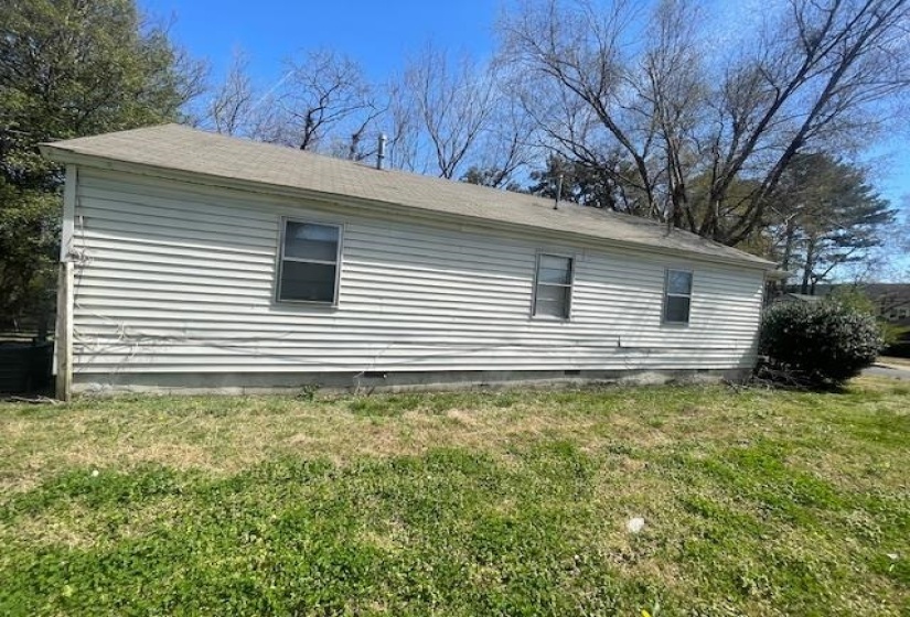 View of side of home with a lawn and crawl space