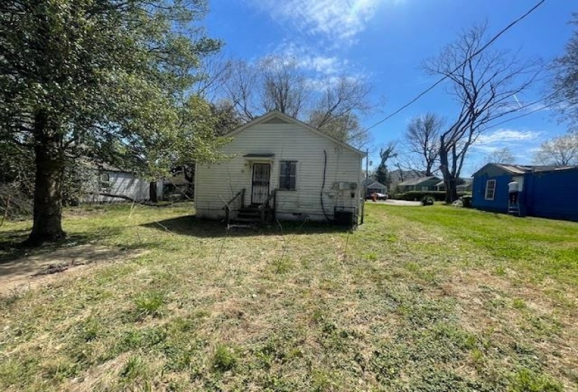 Back of property featuring entry steps and a yard