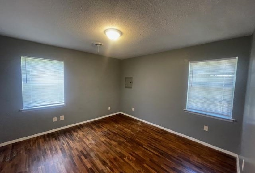 Spare room with dark wood-type flooring, a textured ceiling, and baseboards