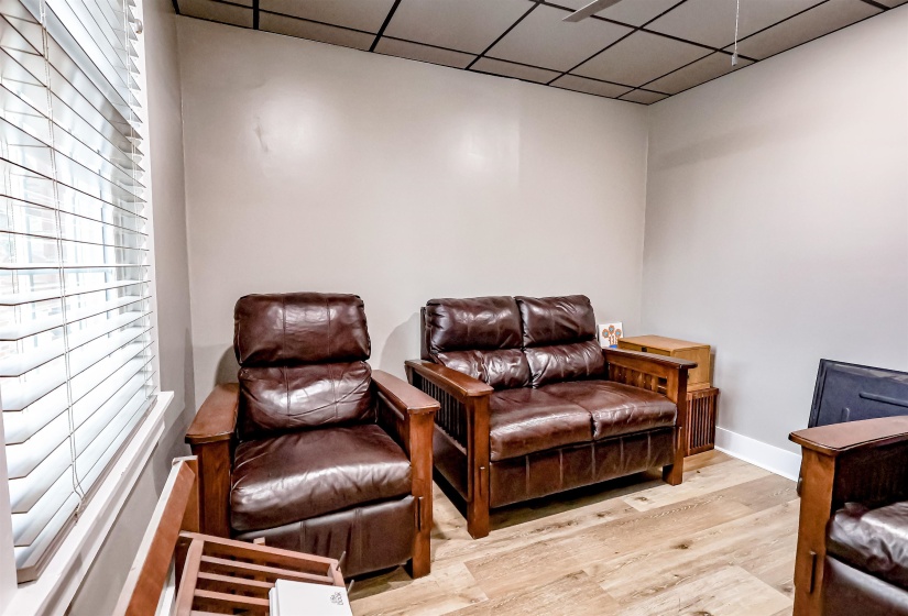 Sitting room featuring baseboards, a drop ceiling, and wood finished floors