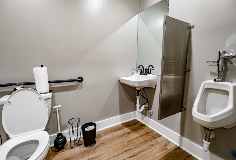 Half bath featuring toilet, a sink, baseboards, and wood finished floors