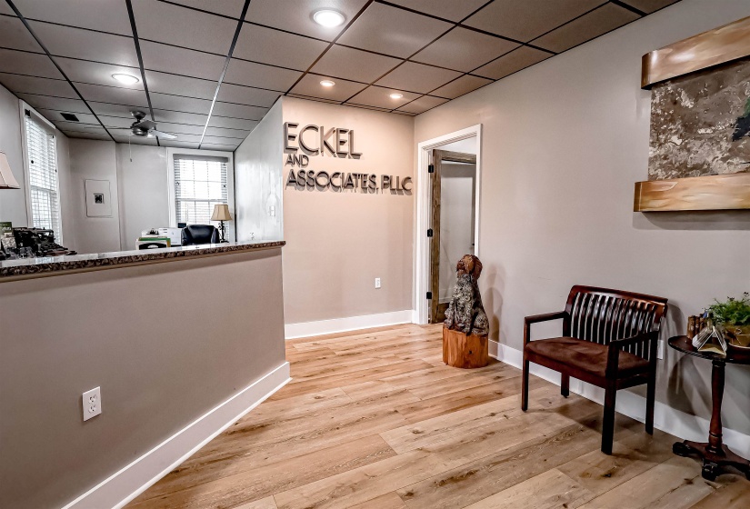 Corridor with a drop ceiling, recessed lighting, baseboards, and wood finished floors