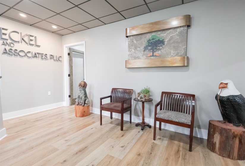Sitting room with baseboards, wood finished floors, a drop ceiling, and recessed lighting