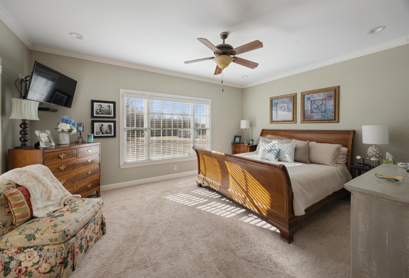 Bedroom featuring baseboards, crown molding, carpet floors, and a ceiling fan