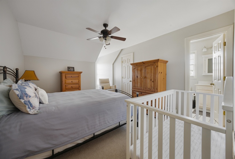 Carpeted bedroom featuring vaulted ceiling and ceiling fan