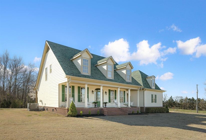 Cape cod home with covered porch, central AC, roof with shingles, and a front yard