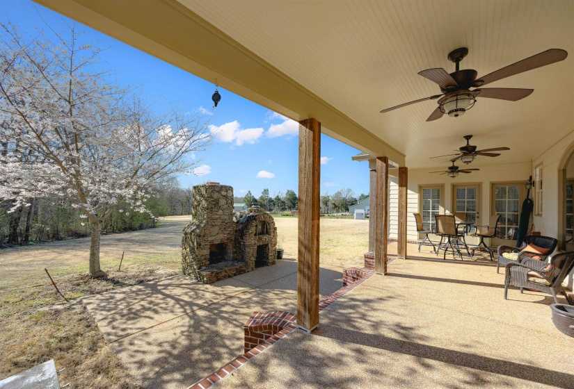 View of patio / terrace with an outdoor stone fireplace and a ceiling fan