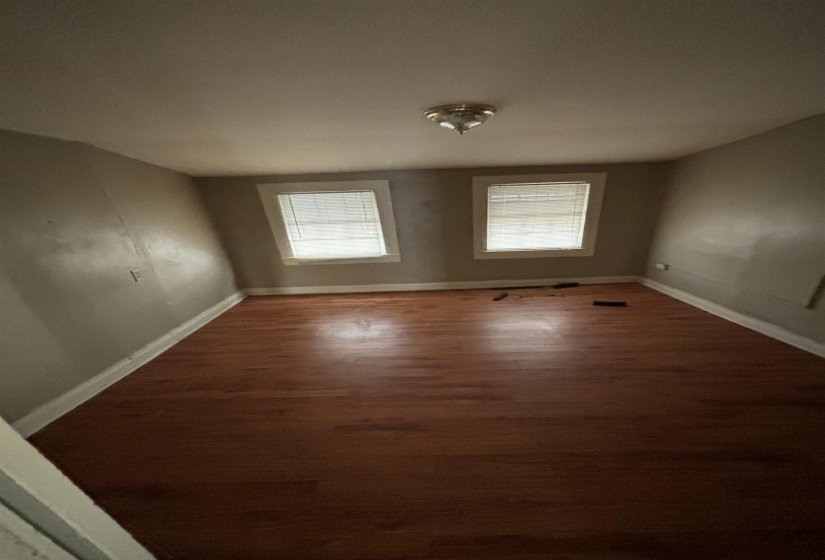 Spare room with baseboards and wood finished floors