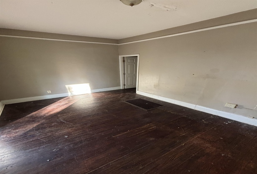 Empty room with baseboards and dark wood-style flooring
