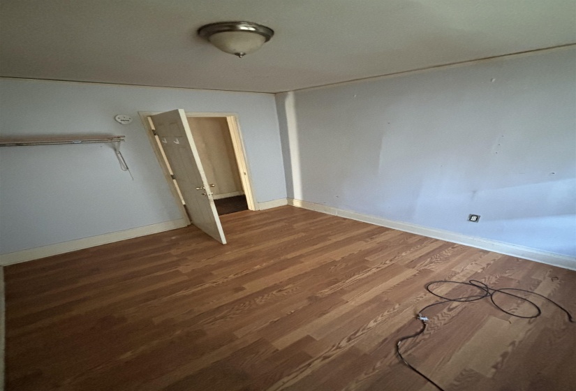Unfurnished bedroom featuring baseboards and wood finished floors