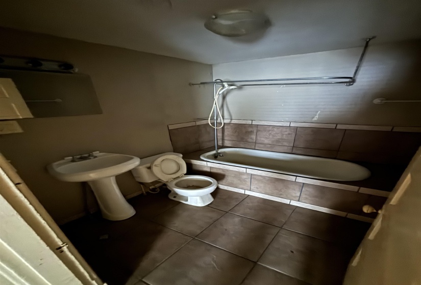 Bathroom with toilet, tile patterned flooring, and tiled shower / bath