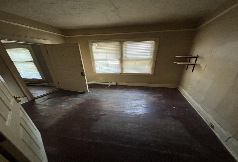Interior space with dark wood-style floors, baseboard heating, and baseboards