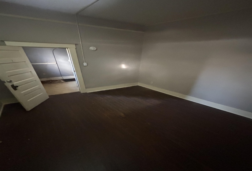 Spare room with dark wood-style floors and baseboards