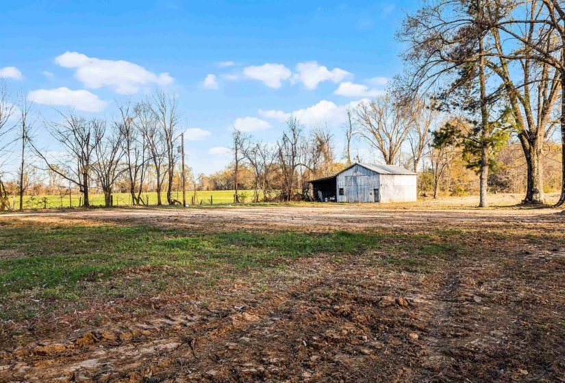 View of yard featuring a rural view, an outdoor structure, and a barn