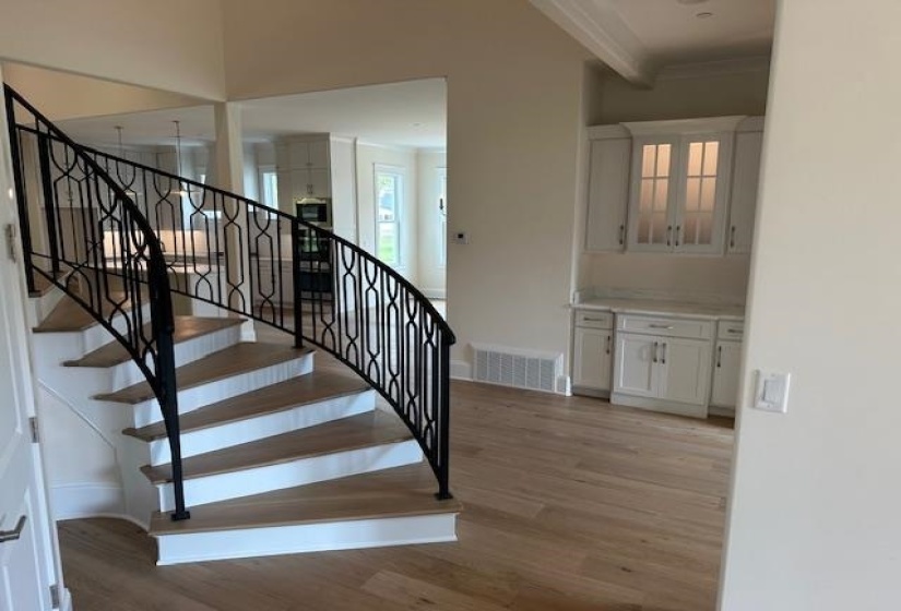 Stairs featuring hardwood / wood-style floors and ornamental molding