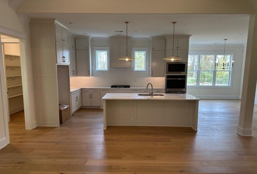 Kitchen with stainless steel appliances, plenty of natural light, a center island with sink, and sink