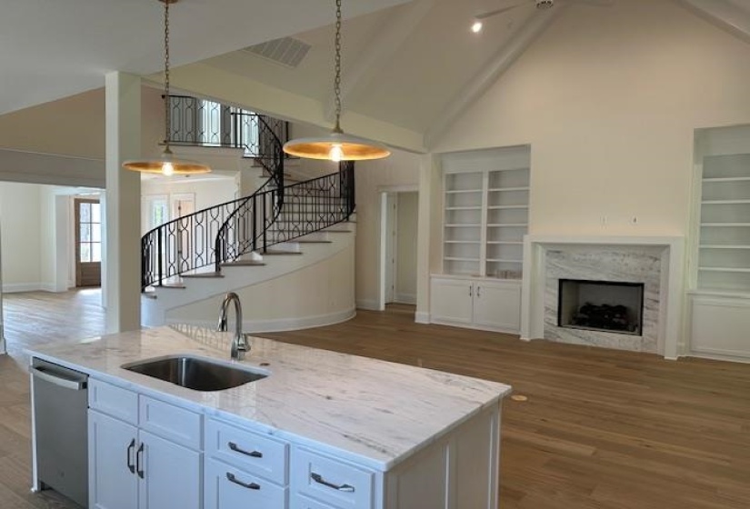 Kitchen with dishwasher, white cabinets, a center island with sink, sink, and hanging light fixtures
