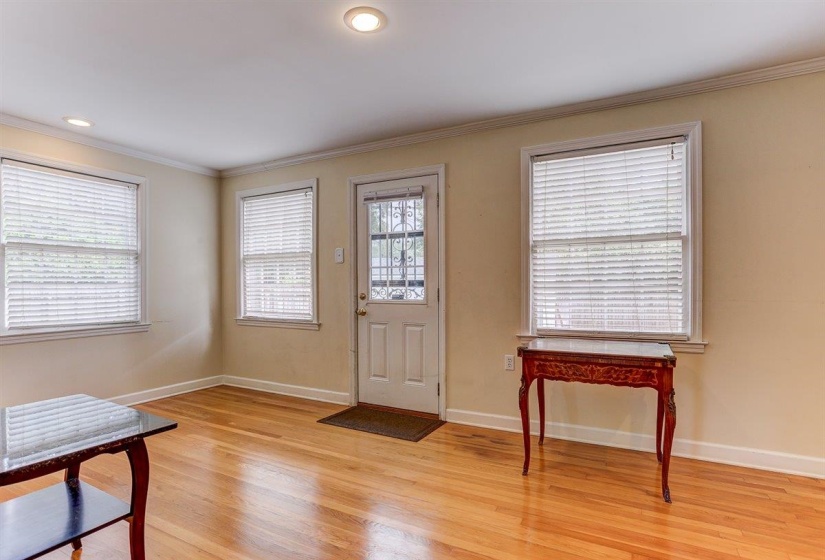 Foyer with ornamental molding, light wood-style flooring, and recessed lighting