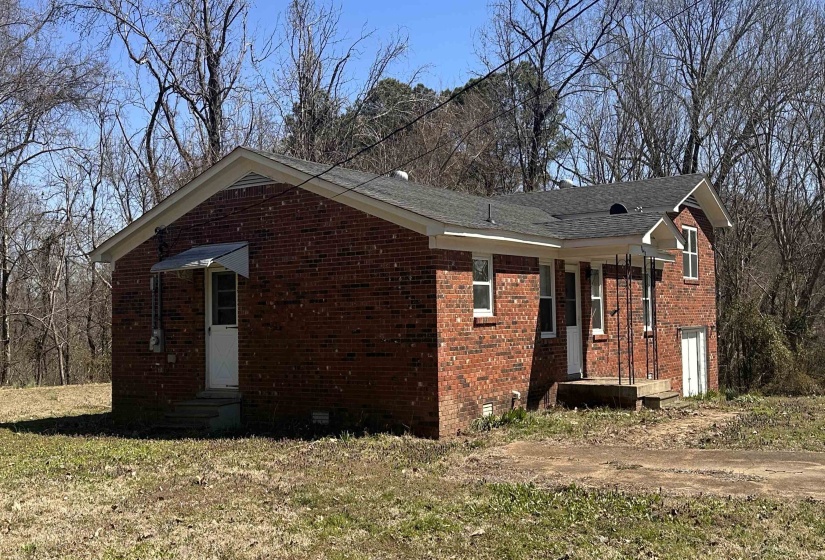 View of home's exterior featuring brick siding, crawl space, and entry steps