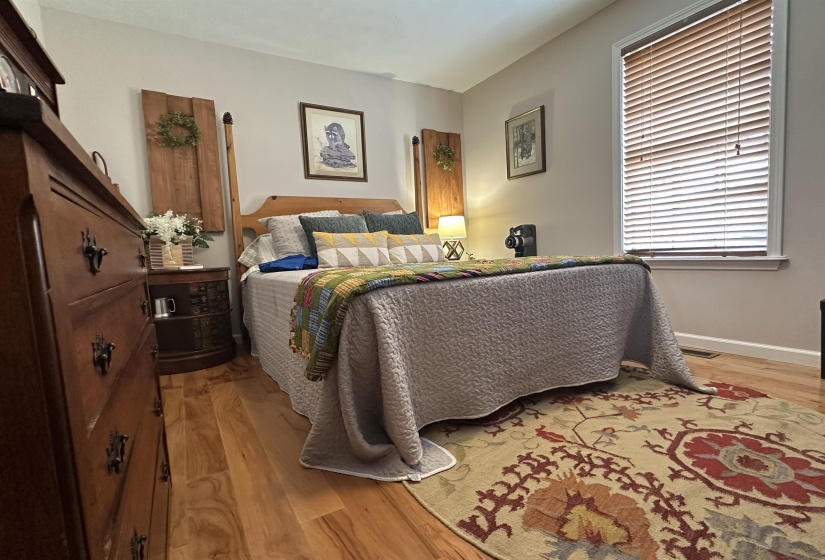 Bedroom featuring baseboards, light wood-style floors, and visible vents