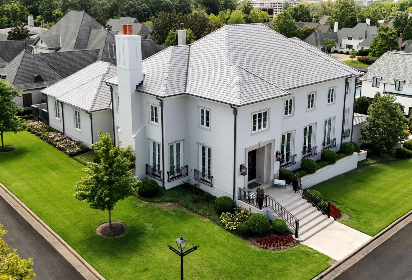 View of front of house featuring a chimney and a front lawn