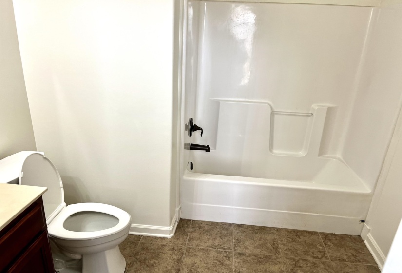 Full bathroom with toilet, vanity, tile patterned floors, and baseboards