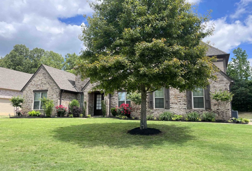 View of front of property featuring brick siding, a shingled roof, and a front yard
