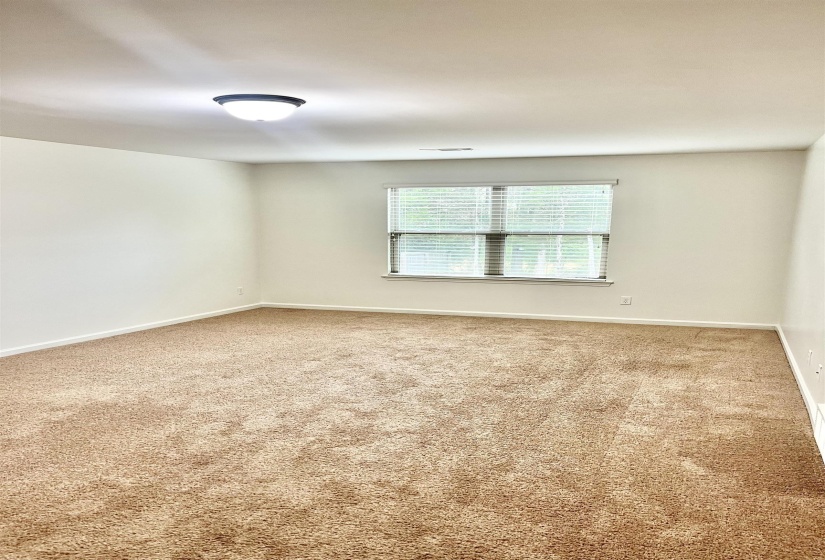 Carpeted spare room featuring baseboards