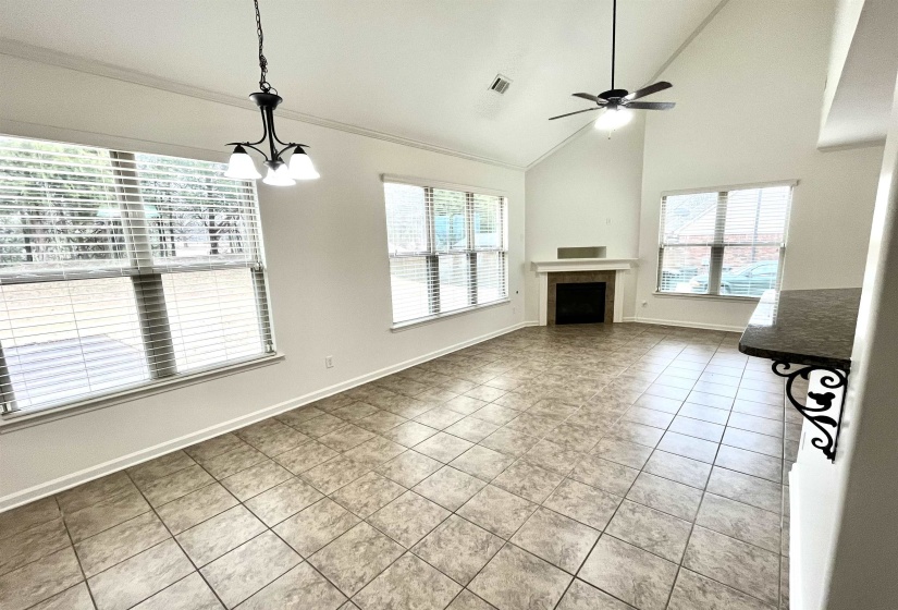 Unfurnished living room featuring a ceiling fan, a healthy amount of sunlight, a fireplace, and visible vents