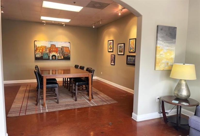 Dining space with rail lighting, arched walkways, baseboards, and finished concrete floors