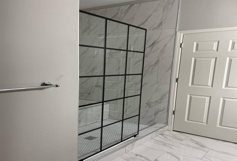 Full bathroom featuring marble finish floor and a stall shower