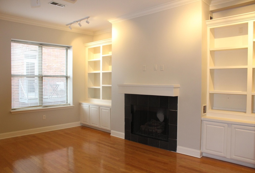 Unfurnished living room featuring baseboards, crown molding, light wood-style floors, and visible vents