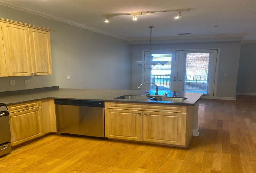Kitchen with crown molding, a sink, visible vents, dishwasher, and light wood-style flooring
