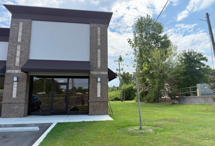Back of property with brick siding and a lawn