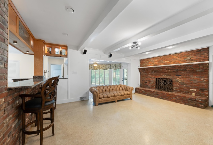 Den with wood or gas fireplace, beamed ceiling, open to kitchen