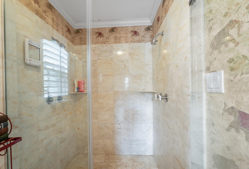 Bathroom featuring a shower with shower door and crown molding
