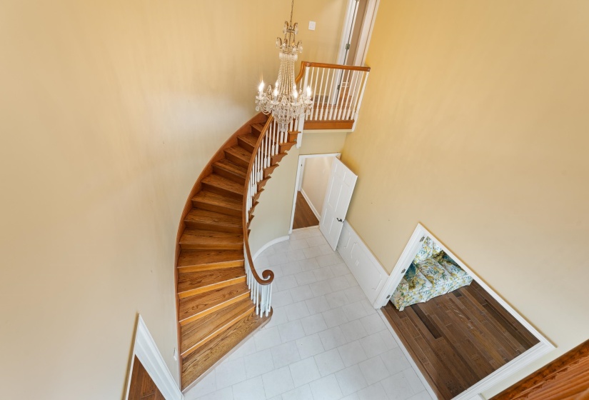 Stairway with a notable chandelier and marble floors