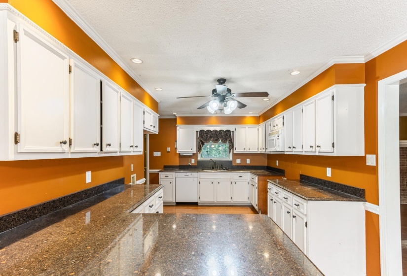 Kitchen featuring white cabinetry, dark stone counters, white appliances, recessed lighting, and a textured ceiling